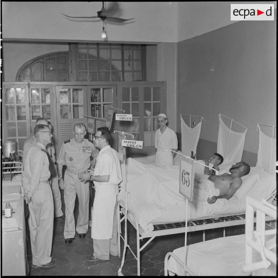 Le général Salan dans une chambre de blessés à l'hôpital militaire Lanessan.