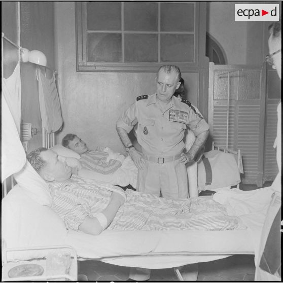 Le général Salan au chevet d'un blessé à l'hôpital militaire Lanessan.