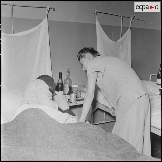 Madame Salan au chevet d'un blessé à l'hôpital militaire Lanessan.