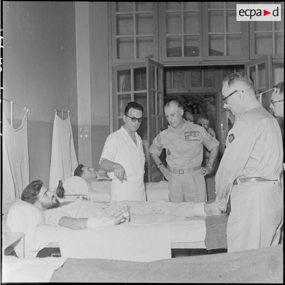 Le général Salan au chevet d'un blessé à l'hôpital militaire Lanessan.