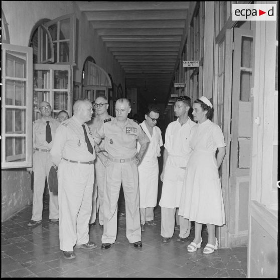 Le général Salan en conversation avec un officier supérieur dans un couloir de l'hôpital militaire Lanessan.