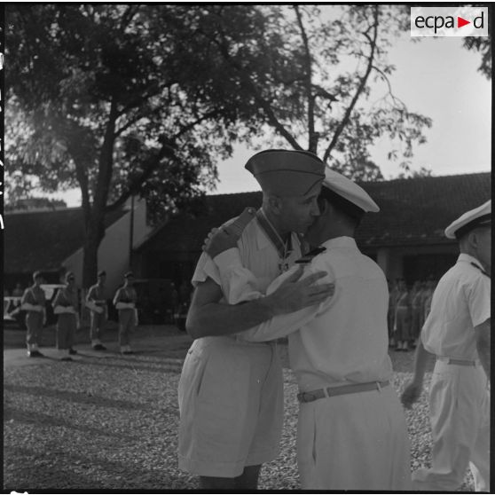 Après lui avoir remis la décoration de l'Ordre national vietnamien, le colonel Van donne l'accolade au colonel Dulac.