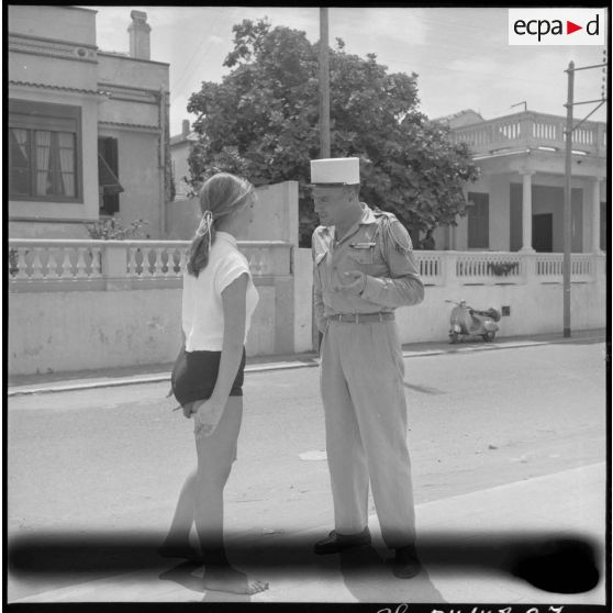 Un légionnaire discute avec une jeune femme dans une rue de Castiglione (Bou Ismaïl).