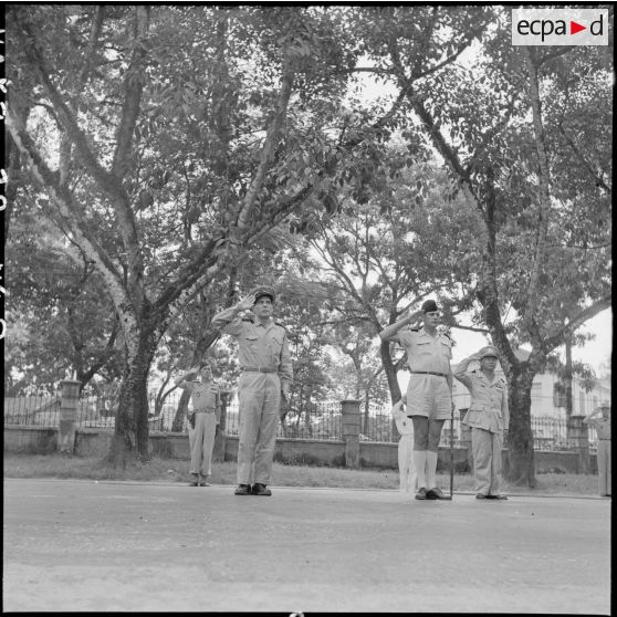 A son arrivée à Hanoï, l'amiral Auboyneau, commandant des forces maritimes d'Extrême-Orient, salue les drapeaux.