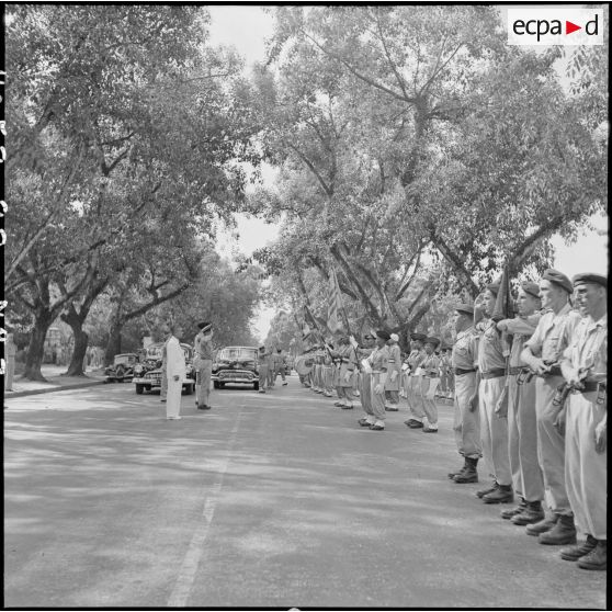 A son arrivée à Hanoï, l'amiral Auboyneau, commandant des forces maritimes d'Extrême-Orient, salue les drapeaux.