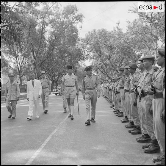 A son arrivée à Hanoï, l'amiral Auboyneau, commandant des forces maritimes d'Extrême-Orient, passe en revue la 5e Cie du 3e BPC (bataillon de parachutistes coloniaux).