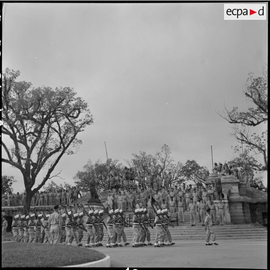 Défilé des troupes devant les ruines de l'ancien musée Maurice Long.