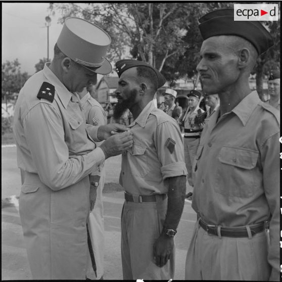 Le général Cogny, commandant en chef des FTNV (forces terrestres du Nord-Vietnam), remet une décoration à un soldat.