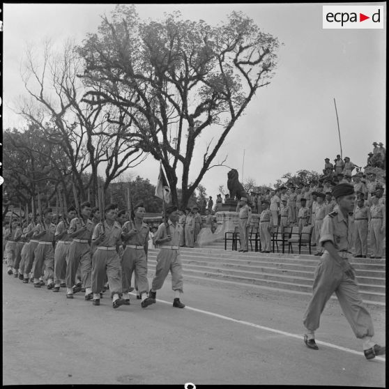 Défilé des troupes devant les ruines de l'ancien musée Maurice Long.
