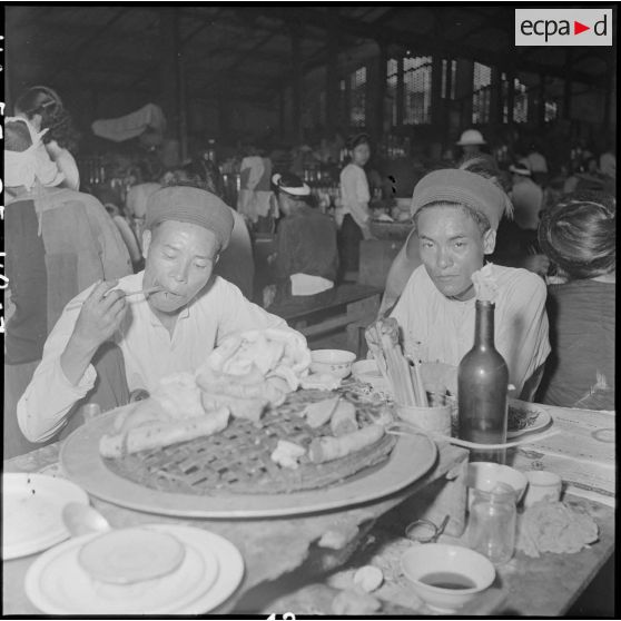 Deux hommes mangeant au grand marché d'Hanoï.
