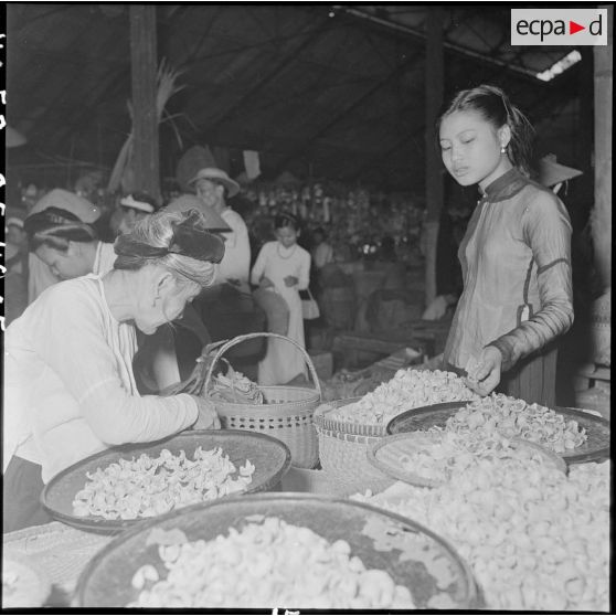 Deux femmes autour d'étal au grand marché d'Hanoï.