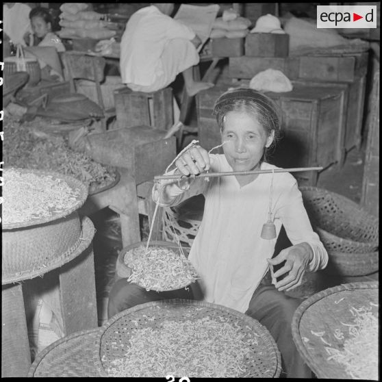 Une femme pèse des pousses de soja au grand marché d'Hanoï.