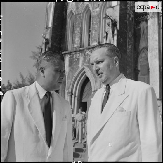Après la messe de requiem organisée à la mémoire du général Chanson, M. Nguyen Huu Tri, gouverneur du Nord-Vietnam, et M. Merlo, délégué général du haut-commissaire de France au Nord-Vietnam, s'entretiennent sur le parvis de la cathédrale Saint-Joseph.