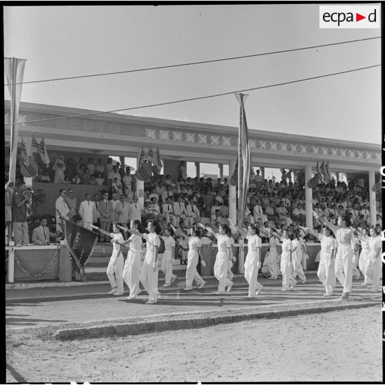 Des élèves défilent devant la tribune officielle au cours d'une manifestation sportive d'écoliers au stade Mangin.