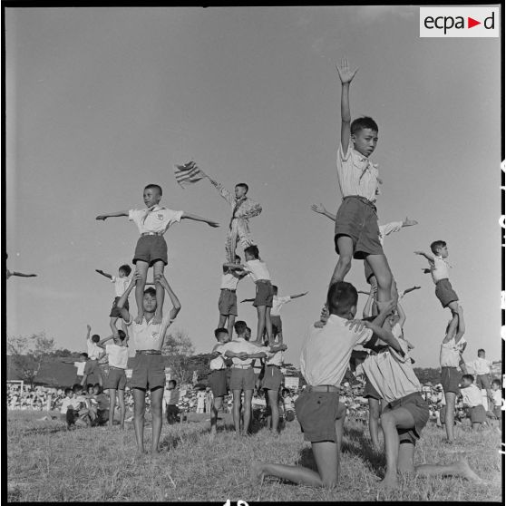 Au cours d'une manifestation sportive d'écoliers au stade Mangin, de jeunes écoliers forment des pyramides.