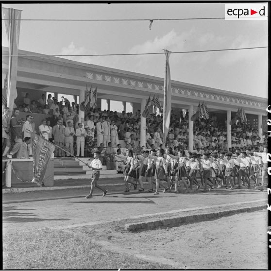 Des élèves défilent devant la tribune officielle au cours d'une manifestation sportive d'écoliers au stade Mangin.