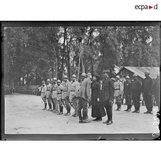 Châlons-sur-Marne (Marne). Remise de décorations par le général Gouraud. Le général Gouraud remet la Croix de Guerre à la directrice des Postes, à droite sapeurs pompiers de Paris qui vont être décorés. [légende d'origine]