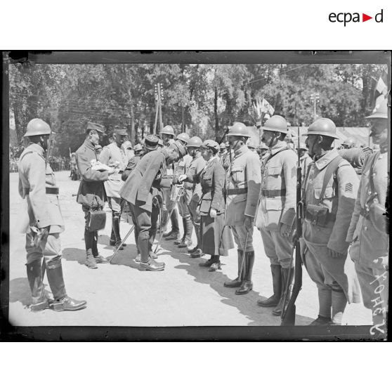 Châlons-sur-Marne (Marne). Remise de décorations par le général Gouraud. Le général Gouraud remet la Croix de Guerre à une conductrice d'ambulance américaine. [légende d'origine]