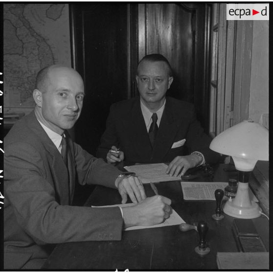 Un officier censeur contrôle certaines informations notées par les journalistes au cours de la conférence donnée au camp de presse d'Hanoï par M. Pleven, ministre de la Défense nationale.