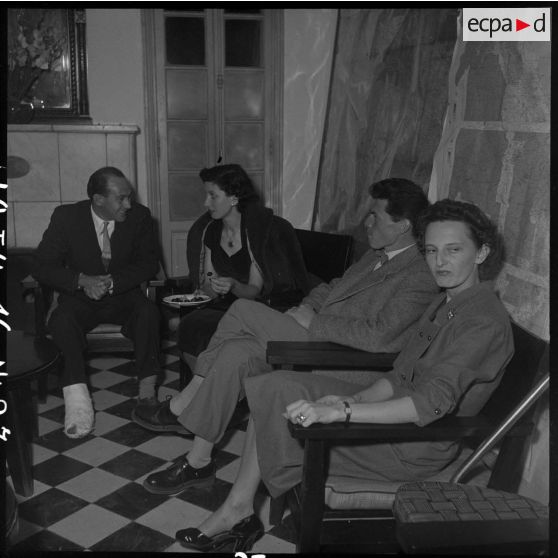 Les photographes du Service presse information (SPI) Paul Corcuff et  Georges Liron  en compagnie de deux femmes au cours d'une réception au camp de presse d'Hanoï.