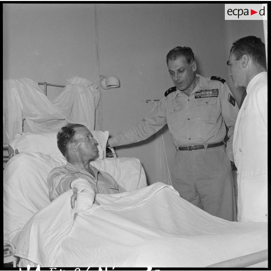Le général Cogny, commandant en chef des FTNV (forces terrestres du Nord-Vietnam), s'entretient avec un soldat blessé à Diên Biên Phu et rapatrié à l'hôpital militaire Lanessan.