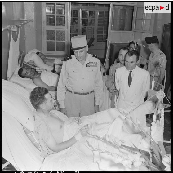 Le général Cogny, commandant en chef des FTNV (forces terrestres du Nord-Vietnam), s'entretient avec un soldat blessé à Diên Biên Phu et rapatrié à l'hôpital militaire Lanessan.