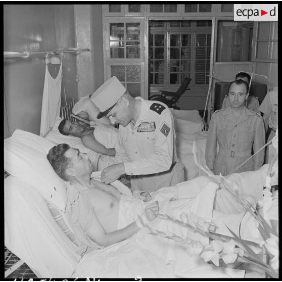 Le général Cogny, commandant en chef des FTNV (forces terrestres du Nord-Vietnam), décore un soldat blessé à Diên Biên Phu et  rapatrié à l'hôpital militaire Lanessan.