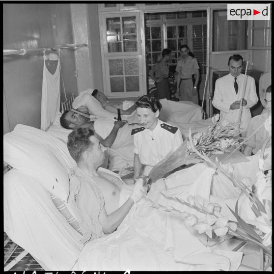 Une femme du PFAT (personnel féminin de l'armée de Terre) s'entretient avec un capitaine blessé à Diên Biên Phu et rapatrié à l'hôpital militaire Lanessan.