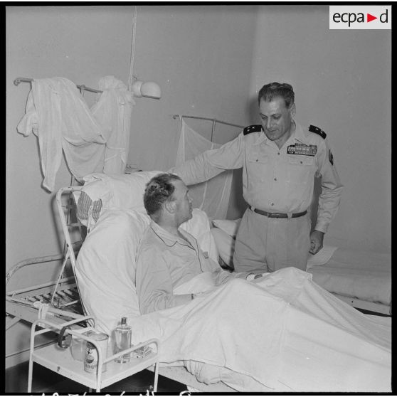 Le général Cogny, commandant en chef des FTNV (forces terrestres du Nord-Vietnam), s'entretient avec un soldat blessé à Diên Biên Phu et rapatrié à l'hôpital militaire Lanessan.