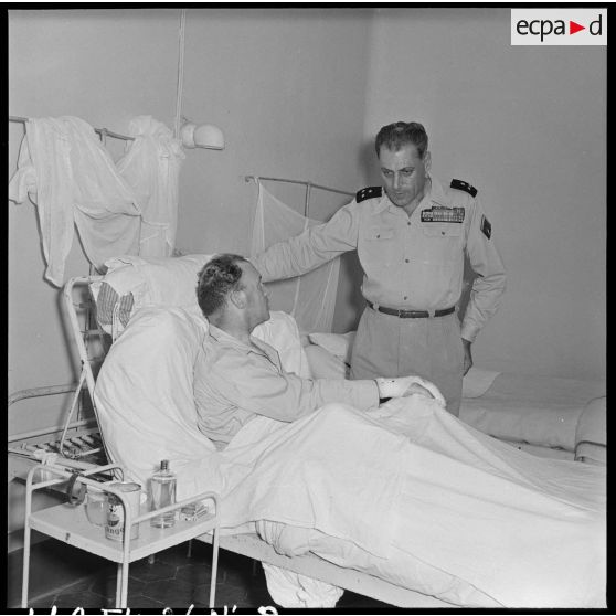 Le général Cogny, commandant en chef des FTNV (forces terrestres du Nord-Vietnam), s'entretient avec un soldat blessé à Diên Biên Phu et rapatrié à l'hôpital militaire Lanessan.