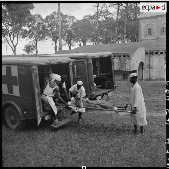 Les brancardiers transportent les derniers blessés évacués de Diên Biên Phu dans la tente de triage.