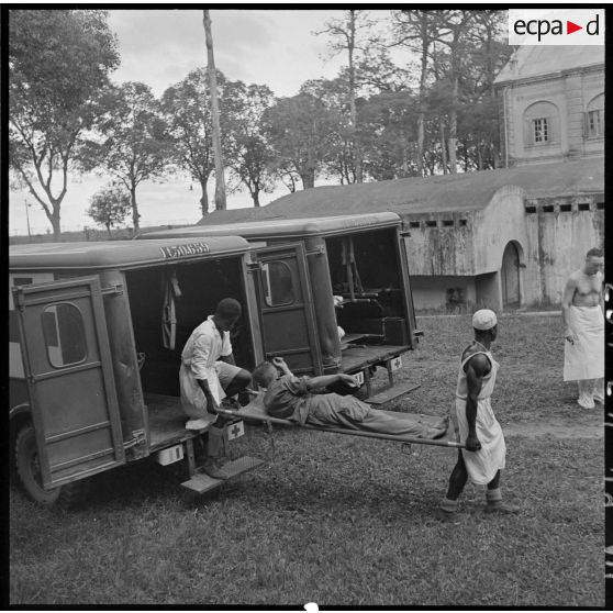 Les brancardiers transportent les derniers blessés évacués de Diên Biên Phu dans la tente de triage.