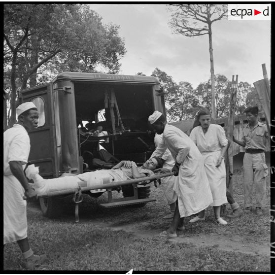 Les brancardiers transportent les derniers blessés évacués de Diên Biên Phu dans la tente de triage.