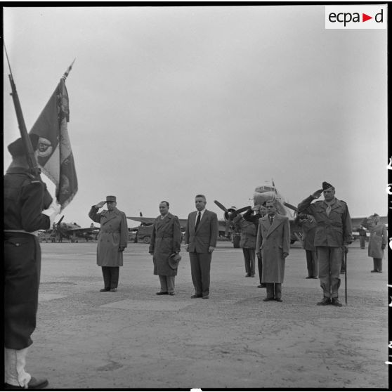 A l'arrivée de M. Jacquet sur l'aérodrome de Bach Mai, les autorités écoutent la Marseillaise.