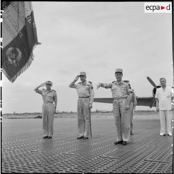 Le général Salan et le général Cogny (à droite), commandant en chef des FTNV (forces terrestres du Nord-Vietnam),  saluent les drapeaux sur la base aérienne de Bach Mai.