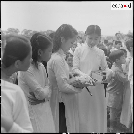 Des jeunes filles regardent leurs prix reçus des frères rédemptoristes.