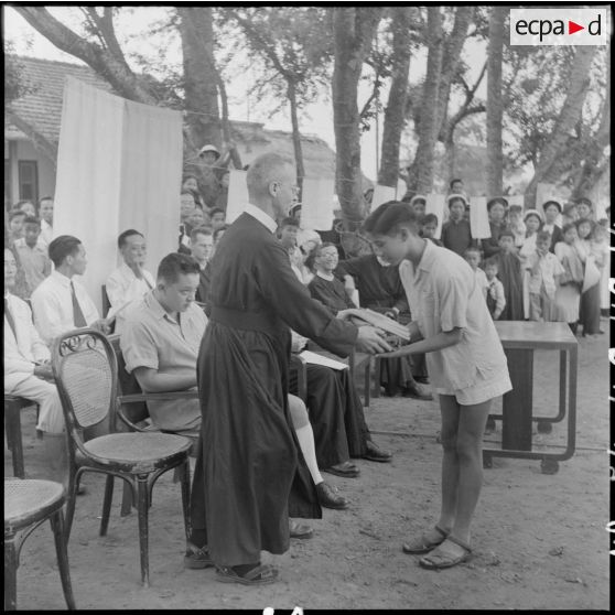 Un frère rédemptoriste remet un prix  à un jeune garçon.