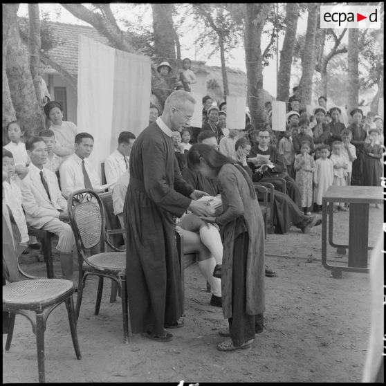 Un frère rédemptoriste remet un prix  à une jeune fille.