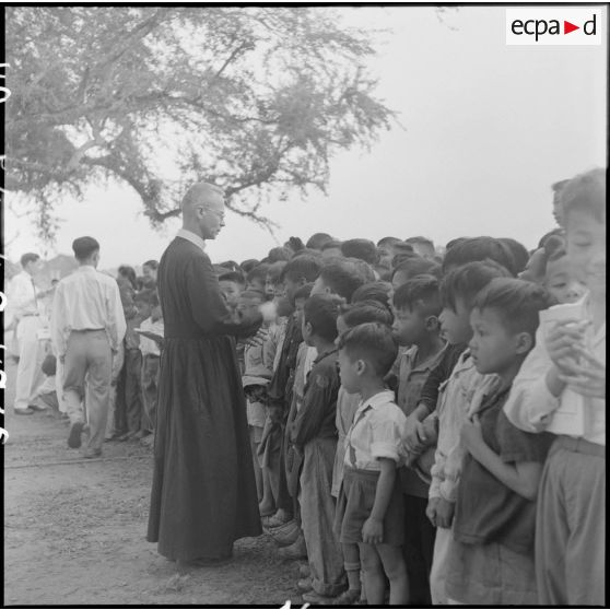 Un frère rédemptoriste devant une foule d'enfants.