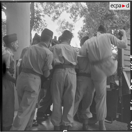 Les soldats installent le cercueil du capitaine Verdier dans un camion militaire.