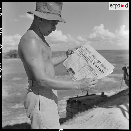 Sur un poste de surveillance de la RN 5, un lieutenant lit la une du journal "L'Entente" annonçant la signature du cessez-le-feu à Genève.