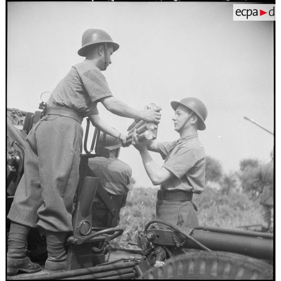 Lors d'une école à feu du 411e RAAA  (régiment d'artillerie antiaérienne) de la DMC (division de marche de Constantine), des artilleurs chargent un canon de 40 mm Bofors.