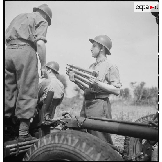 Lors d'une école à feu du 411e RAAA  (régiment d'artillerie antiaérienne) de la DMC (division de marche de Constantine), des artilleurs chargent un canon de 40 mm Bofors.