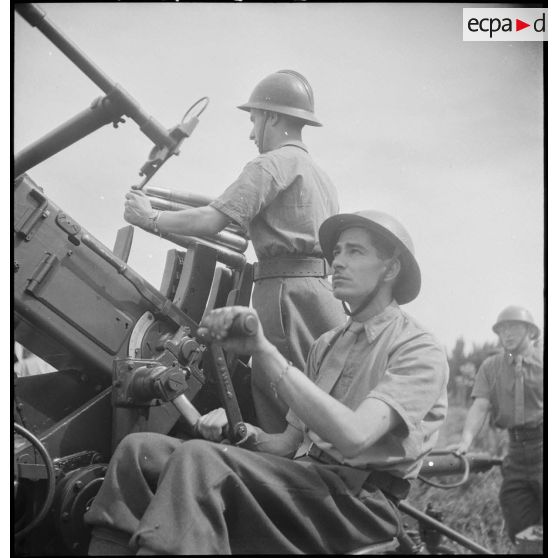 Lors d'une école à feu du 411e RAAA  (régiment d'artillerie antiaérienne) de la DMC (division de marche de Constantine), des artilleurs chargent un canon de 40 mm Bofors.