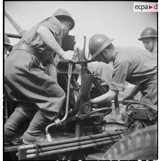Lors d'une école à feu du 411e RAAA  (régiment d'artillerie antiaérienne) de la DMC (division de marche de Constantine), des artilleurs chargent un canon de 40 mm Bofors.