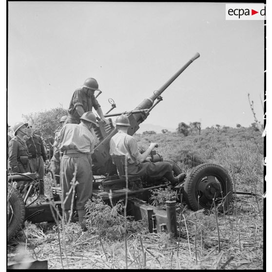 Lors d'une école à feu du 411e RAAA  (régiment d'artillerie antiaérienne) de la DMC (division de marche de Constantine), des artilleurs chargent un canon de 40 mm Bofors.