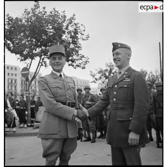 Lors de la cérémonie de remise des chaînes de montage de matériels, dans le cadre du réarmement de l'armée française par les Américains, le brigadier américain, Ernest A. Suttles, responsable de la mise en place des chantiers d'assemblage d'Alger, et le général d'armée René Prioux, major général des forces terrestres et aériennes, échangent une poignée de mains.
