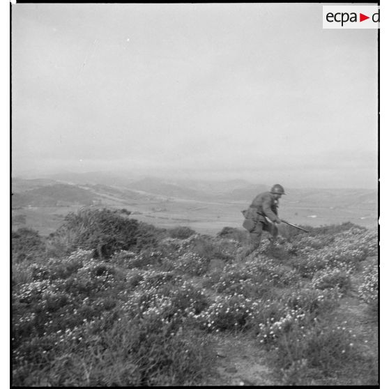 Au cours d'une manoeuvre d'infanterie, un élève de l'école des élèves aspirants ou CIEO (Centre d'instruction des élèves officiers) de Cherchell progresse sur une colline.