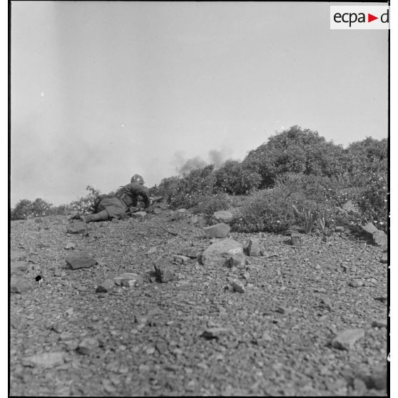 Un élève de l'école des élèves aspirants ou CIEO (Centre d'instruction des élèves officiers) de Cherchell progresse sous le feu au cours d'une manoeuvre d'infanterie.