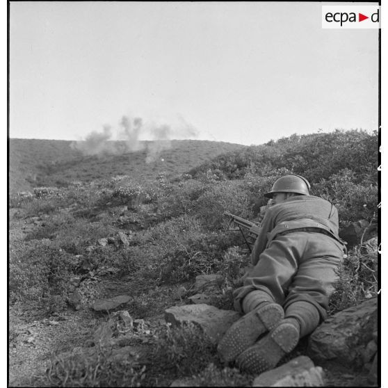 Un élève de l'école des élèves aspirants ou CIEO (Centre d'instruction des élèves officiers) de Cherchell, équipé d'un fusil-mitrailleur 24/29, est en position de tireur couché au cours d'une manoeuvre d'infanterie.